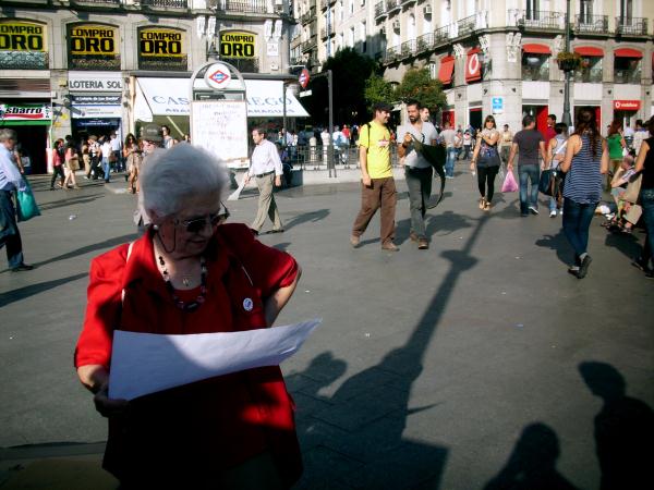 Señora leyendo las reivindicaciones de lxs "indignadxs"